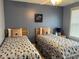 Comfortable bedroom featuring two twin beds, a ceiling fan, and coastal-themed decor at 1516 Edge Dr. # 101, North Myrtle Beach, SC 29582