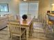 Dining room featuring a wood table, white chairs, decorative lighting, and a view to the living room at 1516 Edge Dr. # 101, North Myrtle Beach, SC 29582