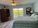Bright main bedroom featuring a queen-size bed, access to a balcony, and a light blue accent wall at 1516 Edge Dr. # 101, North Myrtle Beach, SC 29582