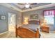 Comfortable bedroom features a ceiling fan, two windows, a wood bed, and neutral carpet at 1581 Culbertson Ave., Myrtle Beach, SC 29577