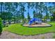 Community playground with slide surrounded by tall trees and lush green grass at 1581 Culbertson Ave., Myrtle Beach, SC 29577