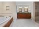 Bathroom showcasing double vanity sinks, a soaking tub, and a separate shower at 1623 27Th Ave. N, North Myrtle Beach, SC 29582