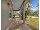 Covered porch with exposed wood flooring and a peek at the landscaping outside at 1623 27Th Ave. N, North Myrtle Beach, SC 29582
