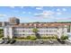 Multi-story condo building with white facade, balconies, parking, and landscaping under a partly cloudy sky at 1919 Spring St. # 36A, North Myrtle Beach, SC 29582