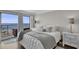 Bedroom featuring sliding glass doors to the balcony with an ocean view, light walls, and wood floors at 2001 S Ocean Blvd. # 406, Myrtle Beach, SC 29577