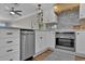 Modern kitchen features white cabinetry, stainless steel appliances, herringbone backsplash, and stylish lighting at 2001 S Ocean Blvd. # 406, Myrtle Beach, SC 29577