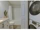 Bathroom featuring granite counters, shower with white curtain, and stacked washer/dryer at 202 Landing Rd. # B, North Myrtle Beach, SC 29582