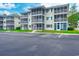 Attractive condominium building with screened porches and ample parking on a sunny day at 202 Landing Rd. # B, North Myrtle Beach, SC 29582