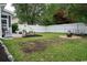 Expansive backyard featuring a fire pit area, patio, lush grass, and a white picket fence at 2039 Chadbury Ln., Myrtle Beach, SC 29588