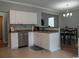 Well-lit kitchen featuring stainless steel appliances, white cabinetry and adjoining dining area at 2039 Chadbury Ln., Myrtle Beach, SC 29588