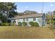 Charming single-story home featuring light blue siding and a well-manicured lawn with mature shrubbery at 210 16Th Ave. N, Surfside Beach, SC 29575