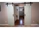 Hallway view featuring light blue sliding barn doors and hardwood floors at 210 16Th Ave. N, Surfside Beach, SC 29575