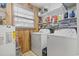 Efficient laundry room with washer, dryer, shelving, and wood-paneled walls at 210 16Th Ave. N, Surfside Beach, SC 29575