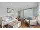Cozy living room with hardwood floors, white sofa with blue pillows, and wicker furniture at 210 16Th Ave. N, Surfside Beach, SC 29575