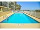 Outdoor pool with lounge chairs, palm trees and clear blue water offers a relaxing vacation spot at 2101 S Ocean Blvd. S # B-6, North Myrtle Beach, SC 29582