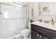 Bright bathroom featuring a walk-in shower, dark vanity, and a mirror with decor hanging on the wall at 230 Palmetto Green Dr., Longs, SC 29568