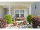 Welcoming front porch with columns, seating, landscaping, and decorative stones at 230 Palmetto Green Dr., Longs, SC 29568