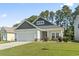 Charming single-Gathering home with manicured lawn and stone-accented facade, bathed in sunlight at 230 Palmetto Green Dr., Longs, SC 29568