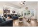 Inviting open-concept living room with hardwood floors, kitchen view and natural light from large windows at 230 Palmetto Green Dr., Longs, SC 29568