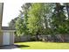 A lush backyard featuring a well-maintained lawn, mature trees, and a wooden fence providing privacy and seclusion at 2429 Westbrook Dr., Conway, SC 29527