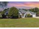 Charming single story home with green lawn, mature tree and manicured landscaping and sunset sky at 2654 Wild Game Trail, Myrtle Beach, SC 29588