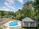 Community pool surrounded by lush greenery, lounge chairs, and a shaded picnic area and blue sky at 2654 Wild Game Trail, Myrtle Beach, SC 29588