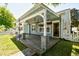 Charming back patio with a lattice-covered pergola, ceiling fans, hanging plants, and stone pillars at 2705 South Key Largo Circle, Myrtle Beach, SC 29577