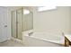 Clean bathroom with a garden tub, glass shower, and neutral tile flooring at 2705 South Key Largo Circle, Myrtle Beach, SC 29577