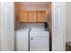 Laundry room featuring a side-by-side washer and dryer with additional storage in the wooden cabinets above at 3012 Sabal Ct., Murrells Inlet, SC 29576