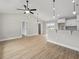 Open-concept living space with hardwood floors, white cabinets, a granite countertop and modern light fixtures at 3415 B And S Rd., Loris, SC 29569