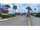 An amusement park entrance with an asphalt drive, palm trees, flags, and shrubbery on a cloudy day at 342 Red Fox Rd., Myrtle Beach, SC 29579