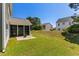 Expansive backyard with a screened porch, level lawn, and view of neighboring homes at 356 Whipple Run Loop, Myrtle Beach, SC 29588