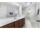 Well-lit bathroom featuring a large vanity with brown cabinets, a mirror, and a combination shower and tub at 356 Whipple Run Loop, Myrtle Beach, SC 29588