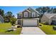 Inviting front exterior showcasing a two-story home with a two-car garage and a landscaped yard at 356 Whipple Run Loop, Myrtle Beach, SC 29588