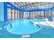 Indoor pool area with clear glass roof offering ample natural light, surrounded by lounge chairs at 4800 S Ocean Blvd. # 708, North Myrtle Beach, SC 29582