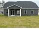 Rear exterior view of home with covered patio, a ceiling fan, and a spacious lawn at 484 Honeyhill Loop, Conway, SC 29526