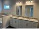 Bathroom featuring double granite vanity, decorative lighting, two mirrors, and tile accents at 484 Honeyhill Loop, Conway, SC 29526