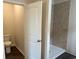 This bathroom features a modern shower with decorative tile, white door, and wood look floors at 484 Honeyhill Loop, Conway, SC 29526