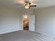 The primary bedroom has neutral colored walls and carpeting, a ceiling fan, and ensuite bathroom at 484 Honeyhill Loop, Conway, SC 29526