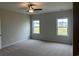 This bedroom has neutral colored walls and carpeting along with two windows for natural light at 484 Honeyhill Loop, Conway, SC 29526
