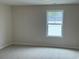 The bedroom features neutral walls, carpeting, and a bright window that offers natural light at 484 Honeyhill Loop, Conway, SC 29526