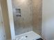 The tiled shower with built-in shelving offers a spa-like experience in this updated bathroom at 484 Honeyhill Loop, Conway, SC 29526