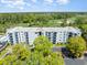 An aerial view showcases the condo building surrounded by verdant trees and a sprawling golf course, with parking nearby at 5001 Little River Rd. # 501E, Myrtle Beach, SC 29577