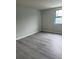 Bedroom featuring gray wood-look floors, light gray walls, and a bright window at 5001 Little River Rd. # 501E, Myrtle Beach, SC 29577