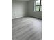Bedroom featuring gray wood-look floors and a bright window at 5001 Little River Rd. # 501E, Myrtle Beach, SC 29577