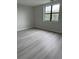 Bedroom featuring gray wood-look floors, light gray walls, and a bright window at 5001 Little River Rd. # 501E, Myrtle Beach, SC 29577