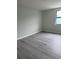 Bedroom featuring gray wood-look floors, light gray walls, and a bright window at 5001 Little River Rd. # 501E, Myrtle Beach, SC 29577