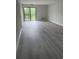 Bright living room with balcony access, neutral paint, and gray wood-look flooring at 5001 Little River Rd. # 501E, Myrtle Beach, SC 29577