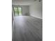 Bright living room with balcony access, neutral paint, and gray wood-look flooring at 5001 Little River Rd. # 501E, Myrtle Beach, SC 29577