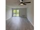 Bright living room with fan, balcony access, neutral paint, and gray wood-look flooring at 5001 Little River Rd. # 501E, Myrtle Beach, SC 29577